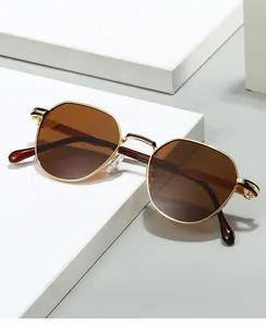 Lunettes de soleil rétro en métal doré avec verres bruns sur présentoir géométrique