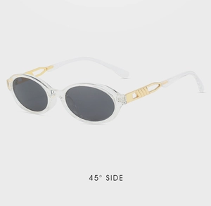 Detail view of oval retro sunglasses with gold hollow metal decor on transparent red frame