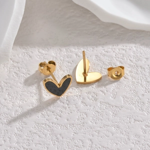 Minimalist gold-plated heart stud earrings with black drip oil on a white stone background