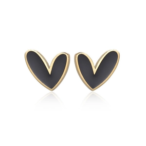 Minimalist heart-shaped gold studs with matte black inlay on a reflective white base