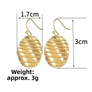 Detail view of gold earrings featuring horizontal wavy texture and oval-shaped design