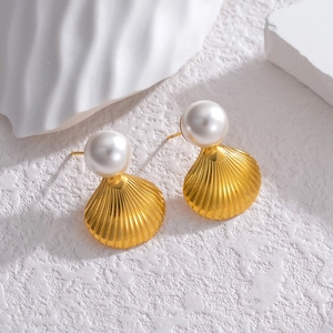 Elegant gold shell stud earrings with white pearl detail on minimalist white background