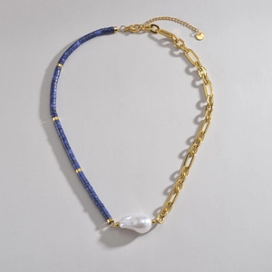 Détail du collier asymétrique avec perles de lapis, chaîne dorée et perle baroque