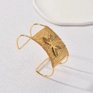 Détail du bracelet manchette tressé doré orné d'une libellule noire et dorée au centre