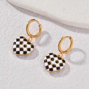 Golden heart earrings with black and white checkerboard pattern in a vintage pop style