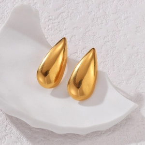Elegant gold waterdrop stud earrings with high-polished finish on white stone stand