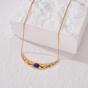 Collier croissant en acier doré avec pierre bleue ovale sur socle en pierre blanche