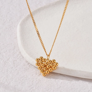 Collier vintage français avec pendentif cœur composé de perles métalliques dorées polies