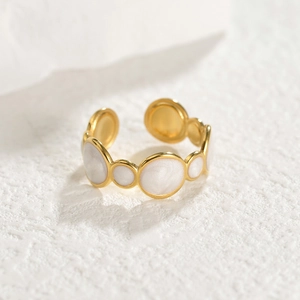 Elegant gold-tone open ring with white enamel circular accents and minimalist design