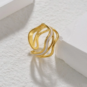 Minimalist gold wave open ring with white enamel detail on a clean stone pedestal