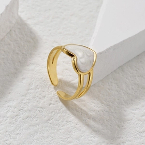 Bague cœur dorée minimaliste avec incrustation de perle blanche sur socle blanc
