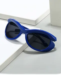 Detail showing sleek dark blue oversized cat-eye computer glasses on white blocks