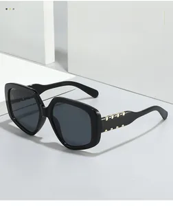 Detail of black oversized square sunglasses with elegant gold metal temple accents