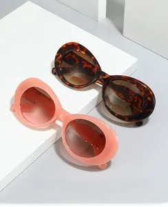 Gros plan de lunettes de soleil ovales écaille et corail sur socles géométriques