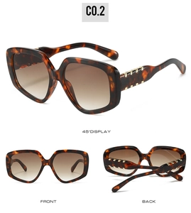 Detail view of large tortoiseshell frame sunglasses with gradient brown lenses and gold accents