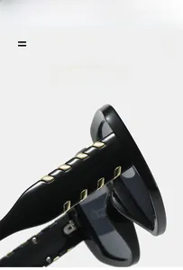 Detailed macro view of black glossy sunglasses temple with golden V-shaped metal decoration