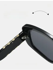 Detail of durable gold-tone metal hinge on wide black frame square sunglasses