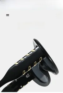 Détail de lunettes de soleil noires avec cinq rivets rectangulaires dorés sur la branche