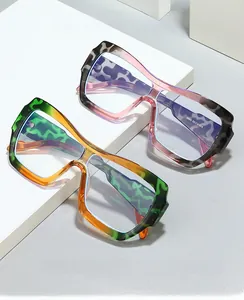 Detail einer übergroßen geometrischen Brille mit floralen Texturen und Verlaufsrahmen