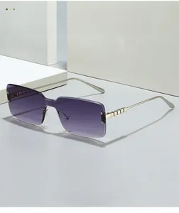 Detail of purple gradient lenses and gold geometric hinges on rimless square sunglasses