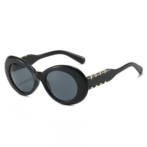 Lunettes de soleil ovales noires épaisses avec détails en métal doré sur les branches