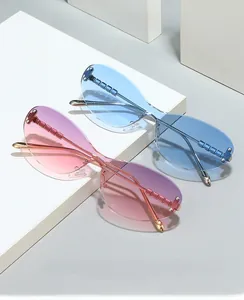 Detail of rimless cat-eye sunglasses with gradient lenses and gold textured metal arms
