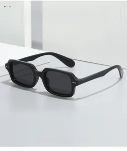 Detail of retro small square sunglasses with dual metal rivet accents on black frames