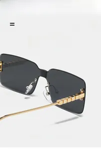 Detailed view of rimless square sunglasses with gold metal temples and cube decorative details