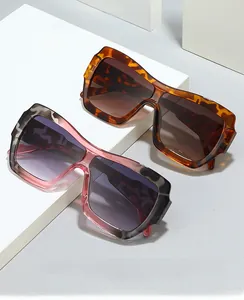 Close-up of oversized square sunglasses with integrated nose pads and tortoise shell texture