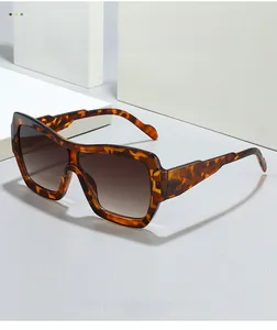 Close-up of square tortoiseshell sunglasses with brown gradient lenses on white blocks