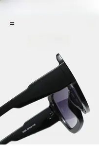 Detail of oversized square sunglasses showing inner temple specifications and texture