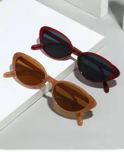 Detail of burgundy and caramel cat-eye sunglasses with dark protective lenses on geometric shapes