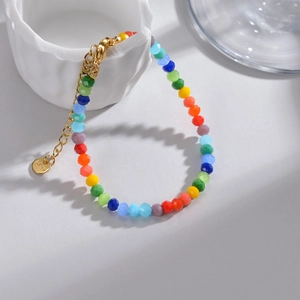 Dettaglio di perline sfaccettate colorate su bracciale in acciaio con targhetta S.steel