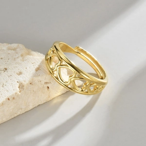 Detailed macro view of gold-plated hollow heart pattern on adjustable open ring band