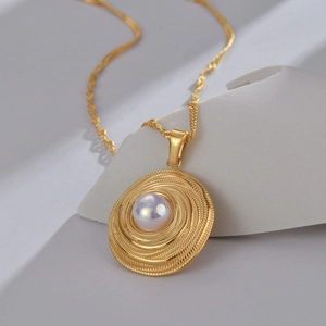 Minimalistische Edelstahl-Halskette mit goldenem Spiral-Perlenanhänger und Wasserwelle
