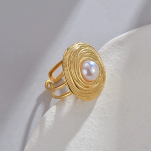 Bague dorée minimaliste avec disque à texture spirale et perle blanche centrale sertie