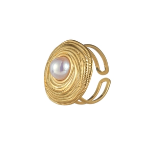 Vue détaillée d'une bague dorée circulaire avec texture concentrique et insert perle