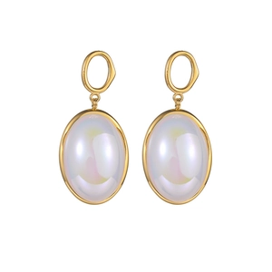 Detail of gold-plated heart earrings with iridescent white shell inlay on white background