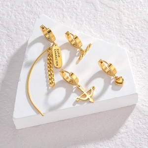 Golden stainless steel earring set with Cupid arrow and heart pendants on white blocks