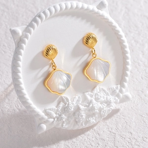 Elegant gold shell earrings with natural mother-of-pearl pendants on display