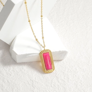 Golden beaded chain necklace with vintage pink rectangular gemstone pendant on white stand