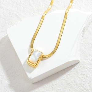 Gold flat snake chain necklace featuring a minimalist rectangular shell pendant on stone