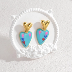 Chic heart-shaped earrings with gold and blue layered pattern on white vintage plate
