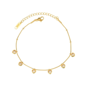 Detailansicht des goldenen Schlangenarmbands mit Herzanhängern und Kristallakzenten