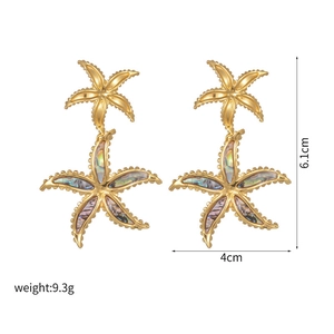 Detail view of gold starfish drop earrings with shell inlay and measurement labels