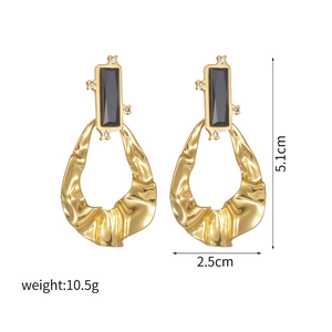 Modern gold oval earrings featuring black resin stone and irregular pleated metal rings