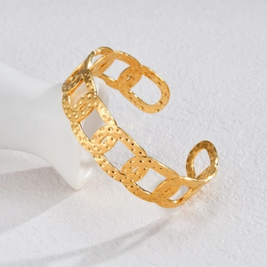 Elegant gold C-shaped open cuff bracelet with hammered texture on white ceramic hand model