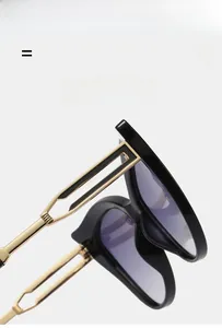 Detail of black acetate cat-eye sunglasses with dual-bar golden hollow metal temples