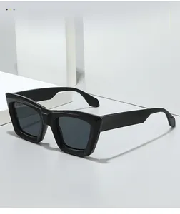Close-up of polished black square sunglasses on minimalist white geometric props