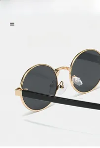 Detail of lightweight flexible golden metal frame and dark round lenses on retro sunglasses